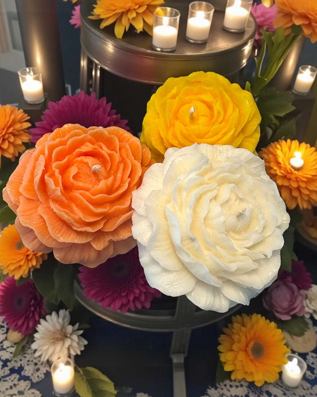 Decorative floral arrangement with candles on a dark surface